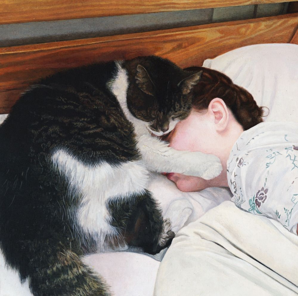 A cat sleeping on the face of a young woman