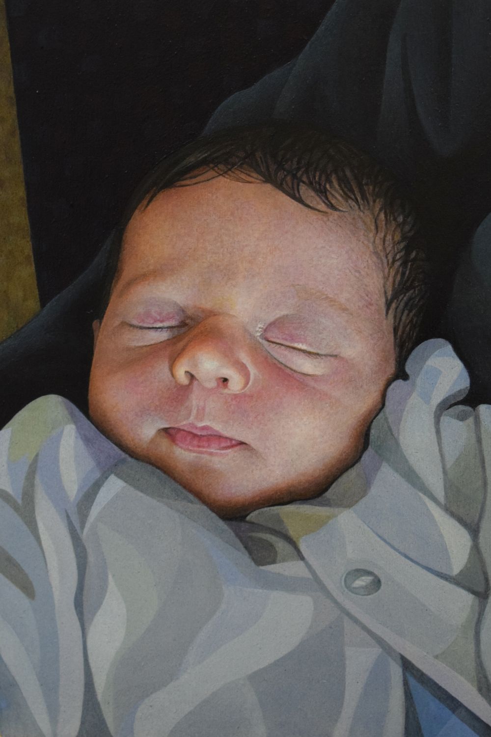 A baby girl with a full head of hair being held in arms