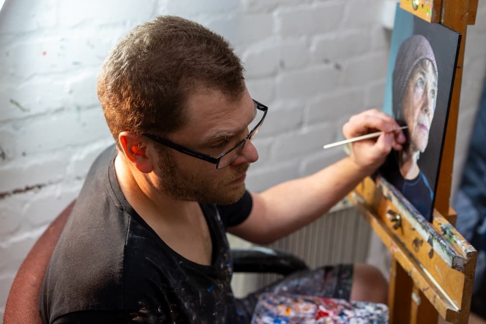 Daniel Murray working at a painting sitting on an easel